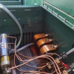 Conjunto de fusível limitador de corrente e conexões de cobre no interior de um gabinete de transformador aberto